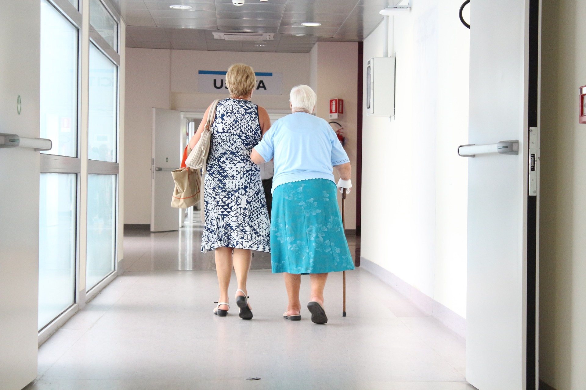 Elderly woman and younger woman walking in hospital